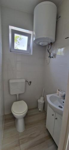 a white bathroom with a toilet and a sink at Funny Füred in Balatonfüred