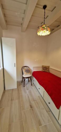 a bedroom with a red bed and a chair at Funny Füred in Balatonfüred