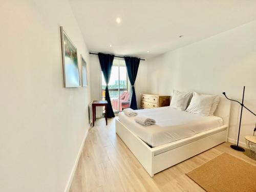 une chambre avec un lit blanc et une fenêtre dans l'établissement PGH N34 - Vue Mer & Port, Climatisé, à La Grande Motte