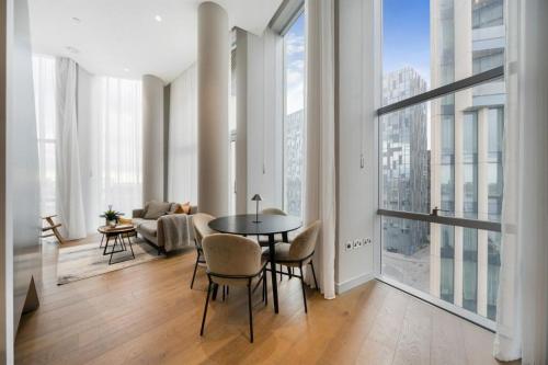 a living room with a table and chairs and a large window at Greenwich-02 in London