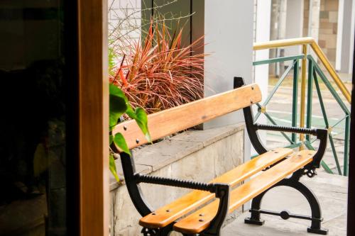 a wooden bench sitting next to a potted plant at Daniel's Apart Hotel in Lima