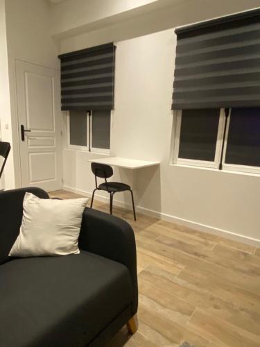 un salon avec un canapé et deux fenêtres dans l'établissement Cozy apartment close to the sea, à Toulon