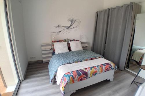 une chambre avec un lit et un miroir dans l'établissement La Bananeraie La Bernerie en Retz, à La Bernerie-en-Retz