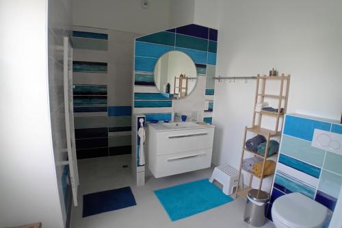 une salle de bain avec un lavabo et un miroir dans l'établissement La Bananeraie La Bernerie en Retz, à La Bernerie-en-Retz