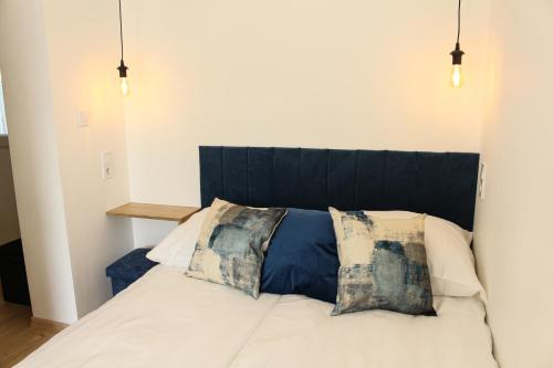 a bedroom with a white bed with two pillows at Tóvidéki Kisház Nyírjes in Nyírjespuszta
