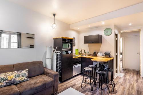 un salon avec un canapé et une cuisine dans l'établissement GuestReady - Appt proche du Canal Saint-Martin, à Paris