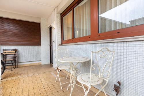 d'une terrasse avec 2 chaises, une table et une fenêtre. dans l'établissement GuestReady - Appartement proche de Montparnasse, à Paris
