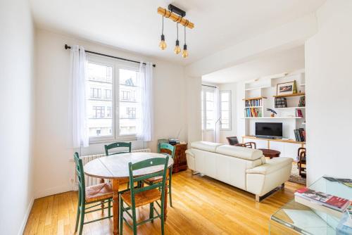 un salon avec une table et un canapé dans l'établissement GuestReady - Homely near Montparnasse Tower, à Paris
