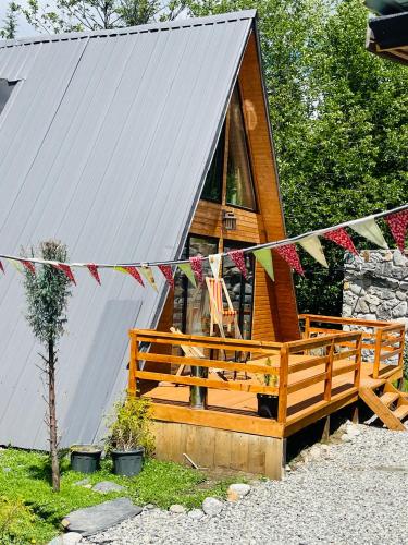 a cabin with a porch and a string of flags at Wooden Huts In Mestia in Mestia