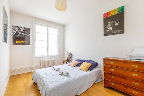 une chambre avec un grand lit et une commode dans l'établissement GuestReady - Homely near Montparnasse Tower, à Paris