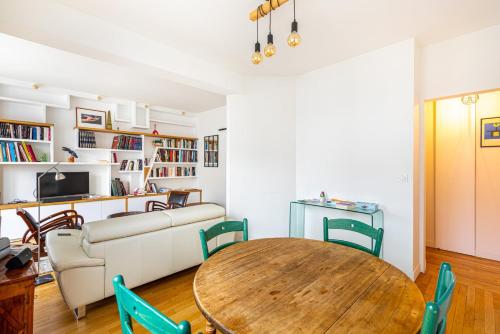 un salon avec une table et un canapé dans l'établissement GuestReady - Homely near Montparnasse Tower, à Paris