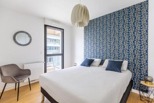 une chambre avec un lit et un mur bleu dans l'établissement GuestReady - Peaceful escape in La Bastide, à Bordeaux