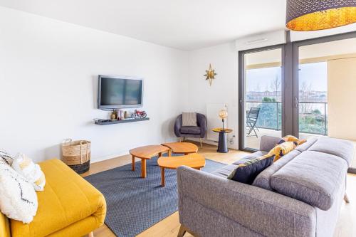 un salon avec un canapé et une télévision dans l'établissement GuestReady - Peaceful escape in La Bastide, à Bordeaux