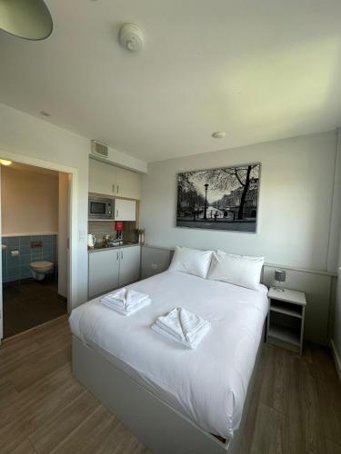 a large white bed with two white towels on it at SWUITE GALWAY in Galway