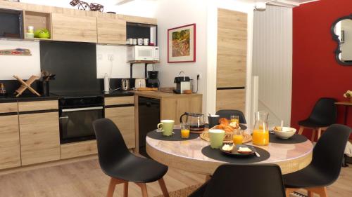 une cuisine avec une table et des chaises dans une pièce dans l'établissement Ravissante maison sur les quais de St Goustan, à Auray