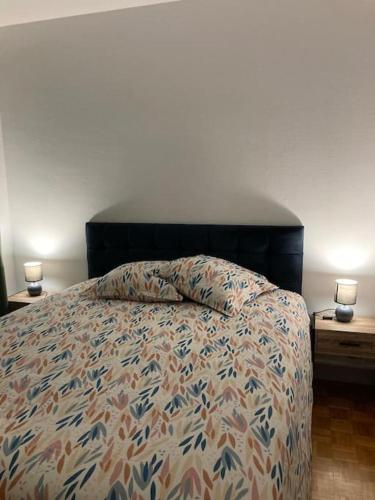 a bedroom with a bed and two nightstands with two candles at Gîte Coccinelle in Saint-Aignan
