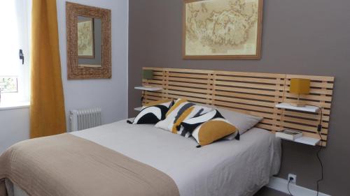 une chambre avec un grand lit avec une tête de lit en bois dans l'établissement Ravissante maison sur les quais de St Goustan, à Auray