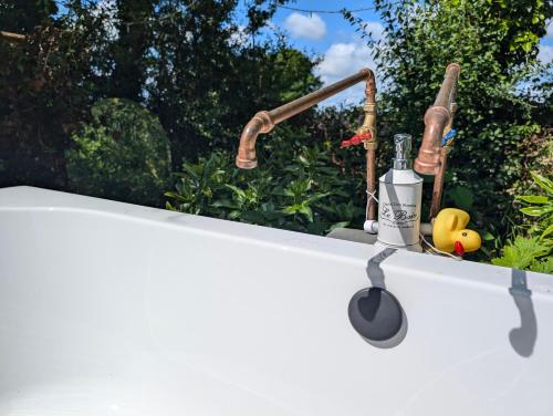 a kitchen counter with a kitchen utensils and a sink at Dreckly cabin - Lydcott Glamping with Cornish sea views in Looe
