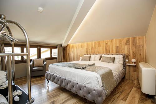 a bedroom with a bed and a chair at Les Clarisses Boutique Hotel in Vic