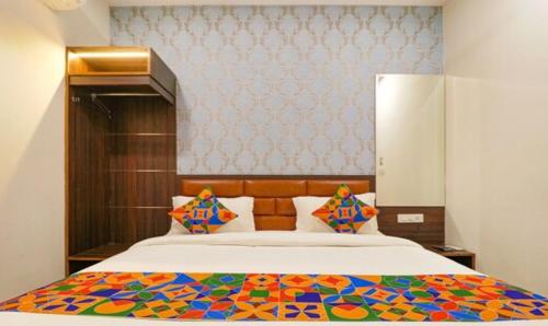 a bedroom with a large bed with a colorful comforter at Hotel California Heights in Amritsar