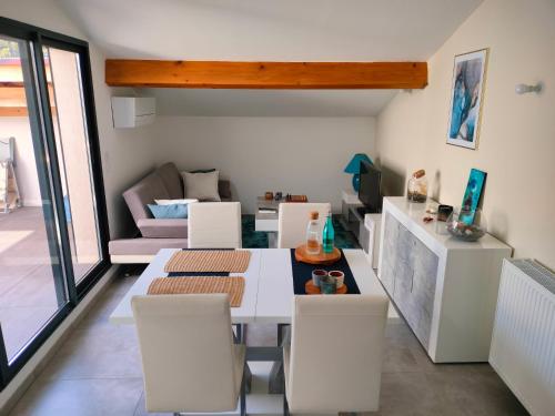 un salon avec une table et des chaises blanches dans l'établissement Appartement T3 de prestige Toulon Cap Brun - proche de la plage, à Toulon