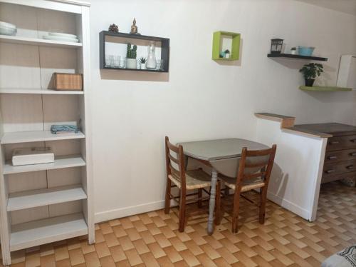 une salle à manger avec une table et une étagère dans l'établissement Studio port de plaisance, à Mauguio