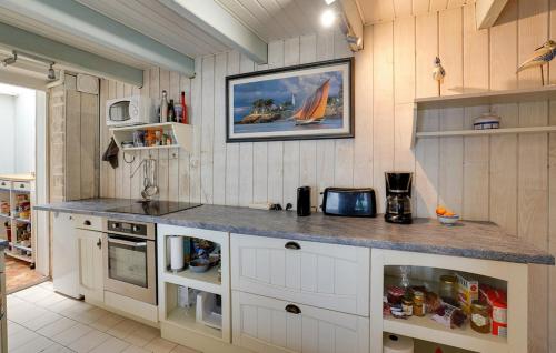 une cuisine avec des armoires blanches et un comptoir dans l'établissement Charmante maison entre centre ville et mer, à La Rochelle