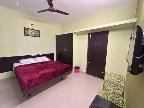 a bedroom with a bed and a ceiling fan at Surya Residency Srirangam in Srīrangam