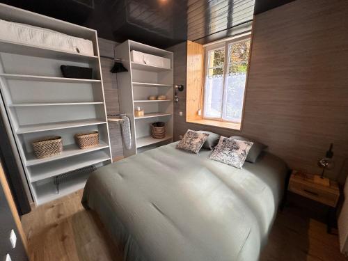 a bedroom with a large white bed and open shelving at Appartement T2 La Belle Epoque in Morteau