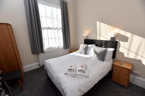 a bedroom with a bed with two shoes on it at Phoenix Court Hotel in Scarborough