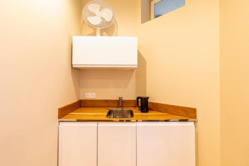 une cuisine avec des armoires blanches et un évier dans l'établissement GuestReady -Beautiful 2-Room in the Heart of Paris, à Paris