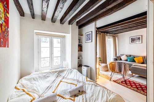 une chambre avec un lit et un salon dans l'établissement GuestReady - Exposed beams flat near Le Marais, à Paris