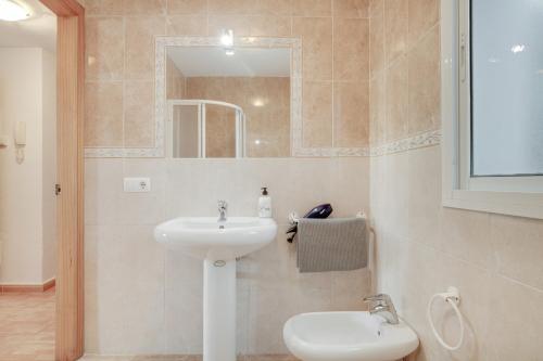 a bathroom with a white sink and a mirror at Piso Ana Paula 1 in Conil de la Frontera