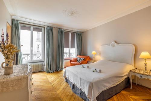 Pokój hotelowy z łóżkiem, krzesłem i oknem w obiekcie GuestReady - Séjour vintage dans le 8e arr. w Paryżu
