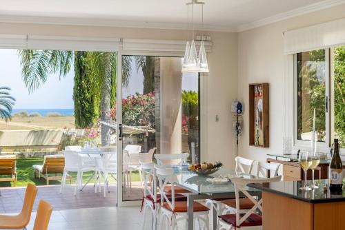 a kitchen and dining room with a table and chairs at Chelidonia Larnaca Seafront Villa in Meneou