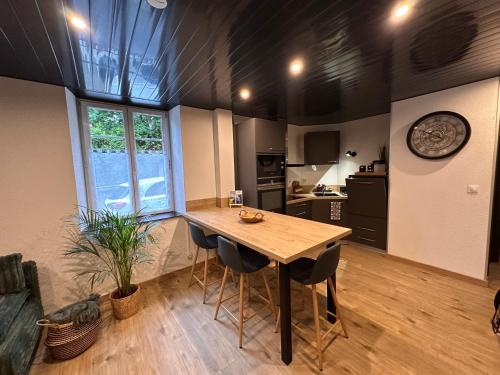 - une cuisine avec une table et des chaises en bois dans la chambre dans l'établissement Appartement T2 La Belle Epoque, à Morteau