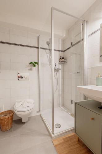 a white bathroom with a shower and a toilet at Charmant studio au centre de Saas-Fee in Saas-Fee