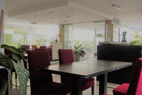 a dining room with a table and red chairs at Hotel Castilla in Punta del Este
