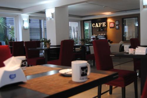 a restaurant with tables and chairs and a coffee cup at Hotel Castilla in Punta del Este