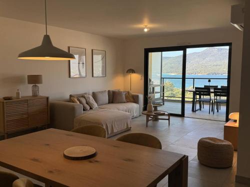 un salon avec un canapé et une table dans l'établissement Appartement tout confort vue mer, à Propriano