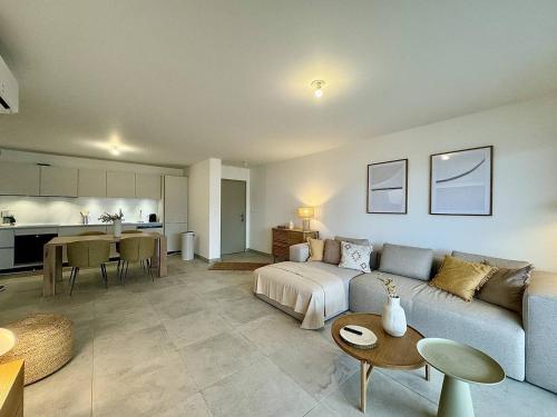 un salon avec un canapé bleu et une cuisine dans l'établissement Appartement tout confort vue mer, à Propriano