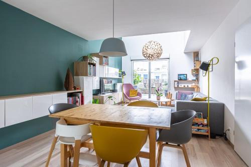 une cuisine et une salle à manger avec une table et des chaises en bois dans l'établissement GuestReady - Stylish Retreat in Bacalan, à Bordeaux