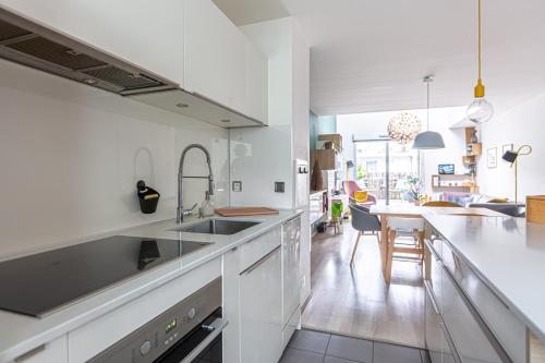 une cuisine avec des placards blancs et une salle à manger dans l'établissement GuestReady - Stylish Retreat in Bacalan, à Bordeaux