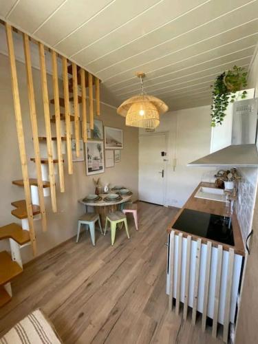 une cuisine et une salle à manger avec une table et un escalier dans l'établissement LA PERLE, Studio 50 m de la PLAGE , parking, clim, Rivage Privilège, à La Seyne-sur-Mer