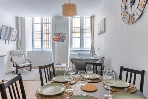 une salle à manger avec une table, des verres et des chaises dans l'établissement GuestReady - Flat in the city centre, à Bordeaux