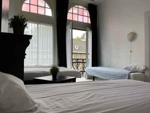 a bedroom with two beds and a window at Hotel Galerij in Amsterdam