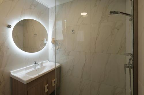 a bathroom with a sink and a shower with a mirror at Zeus Throne Suites in Afionas