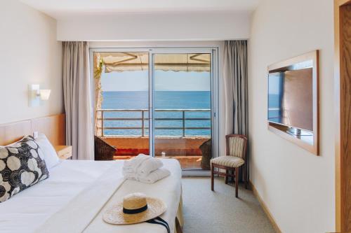 a hotel room with a bed and a view of the ocean at Alivi in Bastia