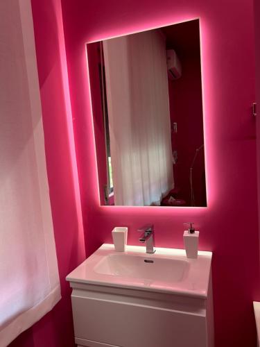 a pink bathroom with a sink and a mirror at Spazio DIBA in Ortona