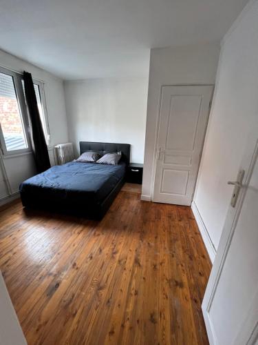 une chambre avec un lit et un parquet dans l'établissement Appt 2 pcs st Quentin Centre, à Saint-Quentin